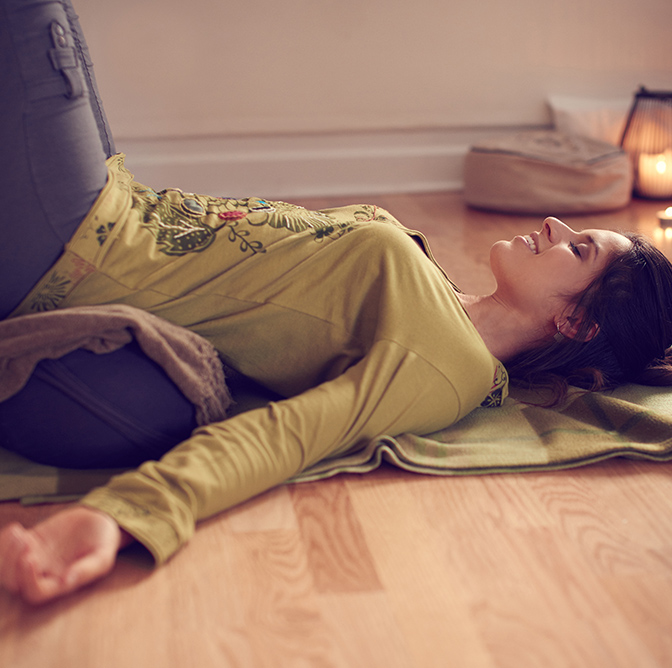Woman on a bolster stretching her back